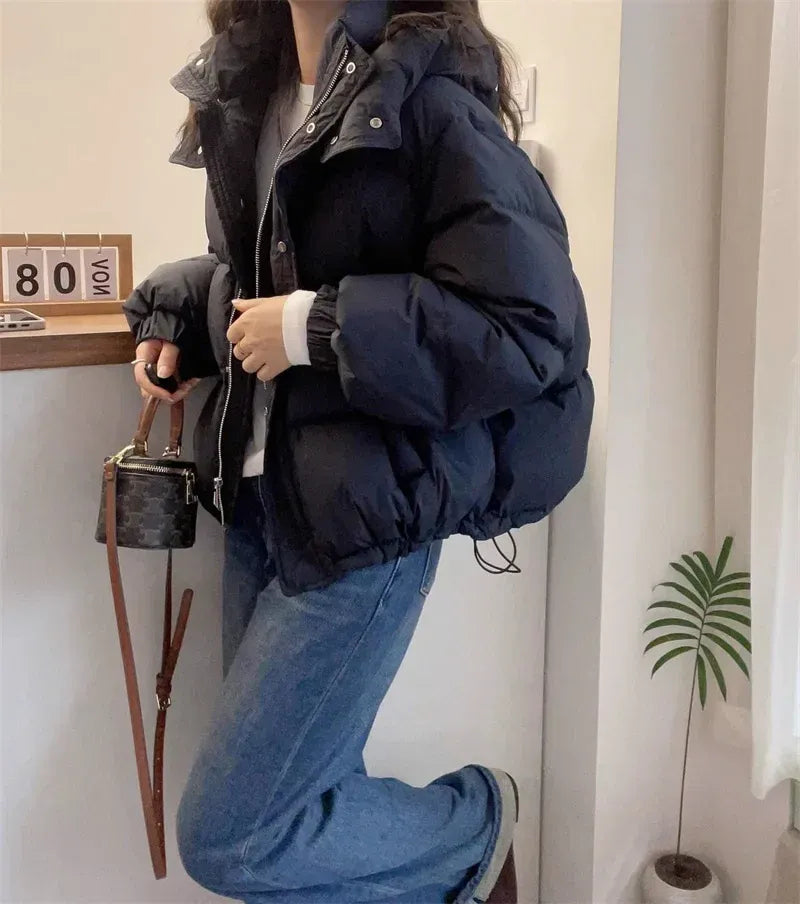 Back view of women's black quilted puffer jacket with relaxed oversized fit