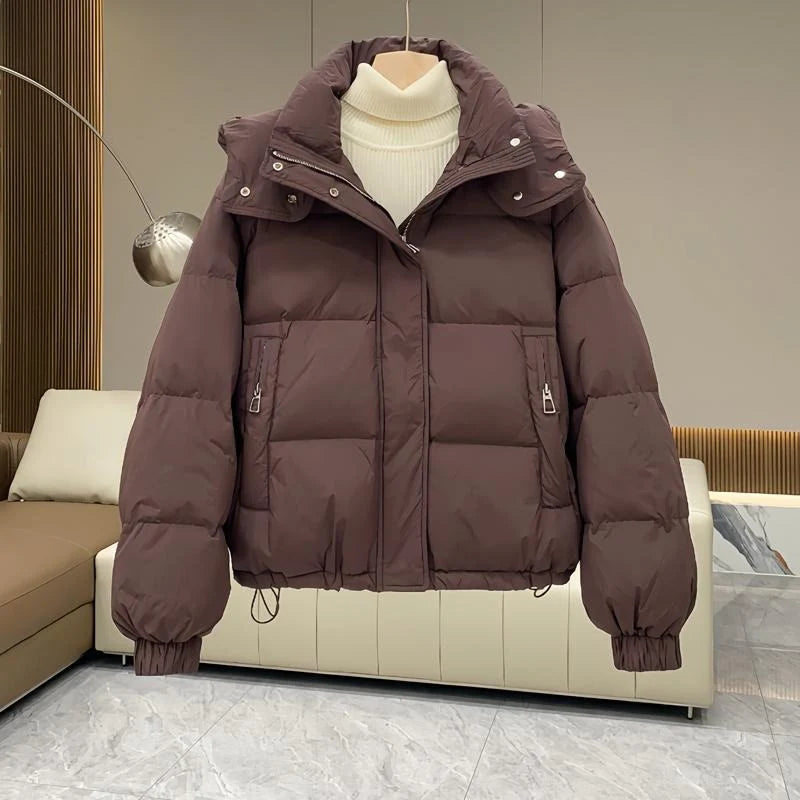 Front view of women's black hooded puffer jacket showing full-length zip and storm flap