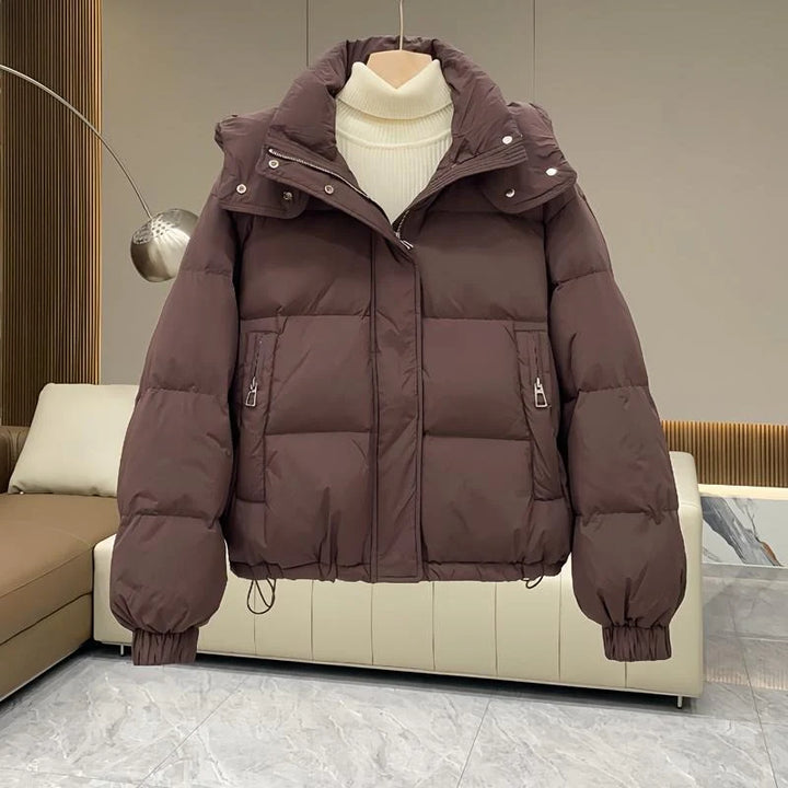 Front view of women's black hooded puffer jacket showing full-length zip and storm flap