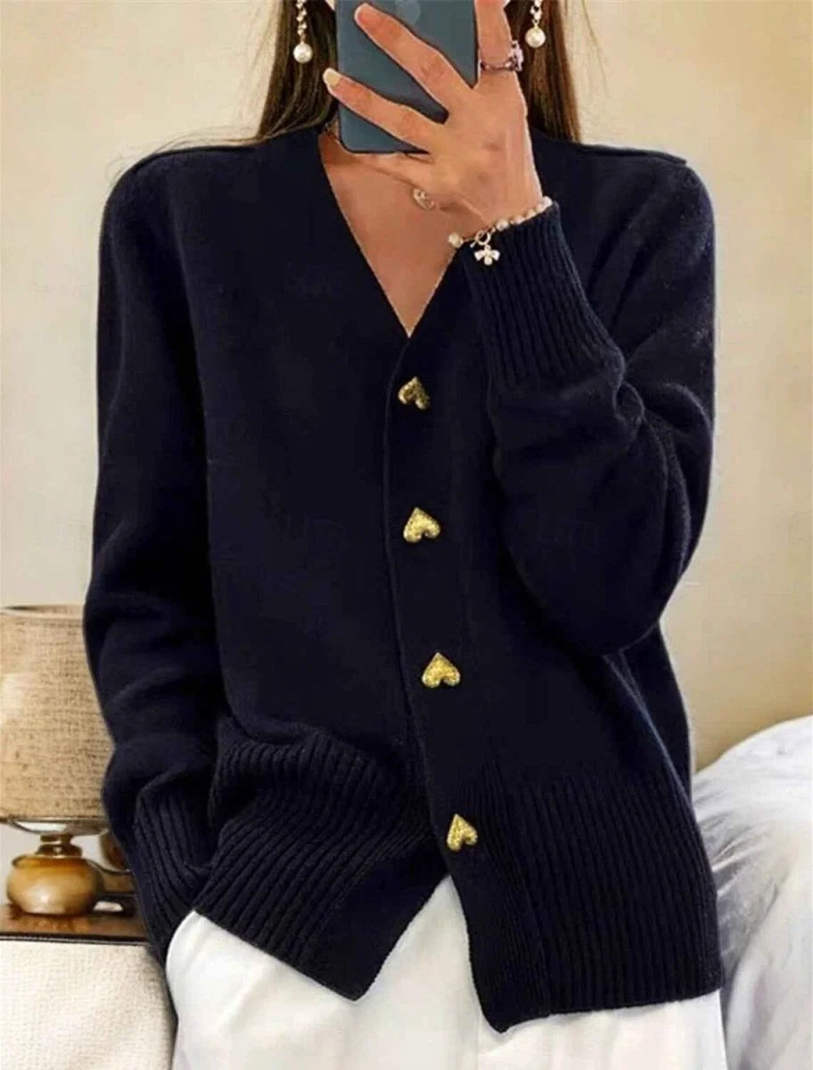 Close-up view of gold heart-shaped buttons on women's relaxed fit knit cardigan with ribbed trim