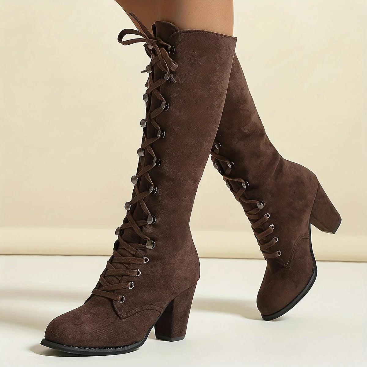 Women's block heel knee-high boots showing full shaft length and adjustable lace-up closure