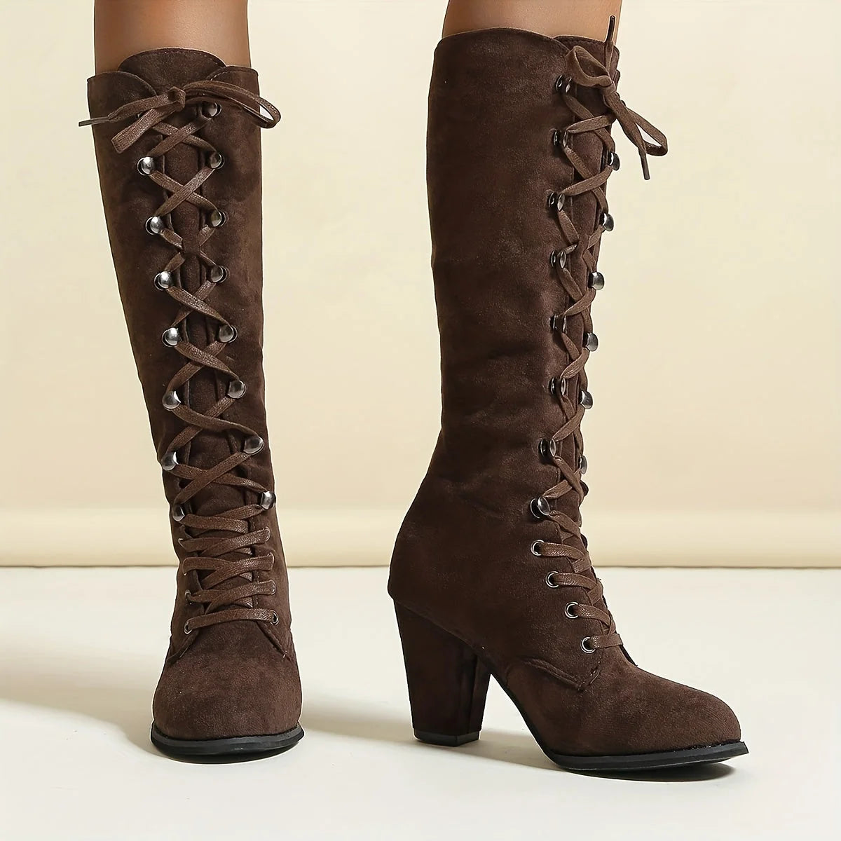 Front view of women's lace-up knee-high boots displaying adjustable fit and heel height