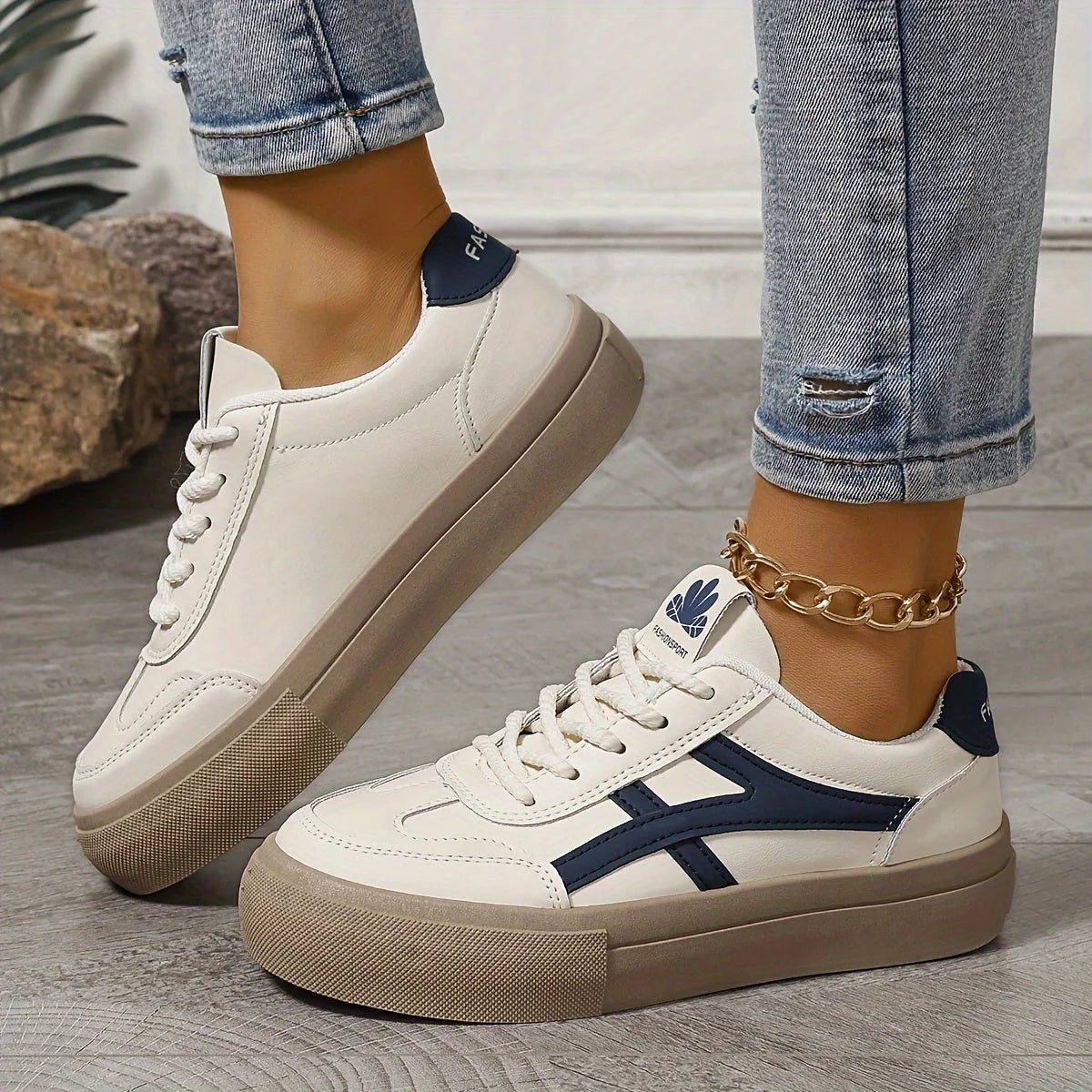 Women's platform trainers with chunky sole and navy contrast stripe detail worn with distressed jeans