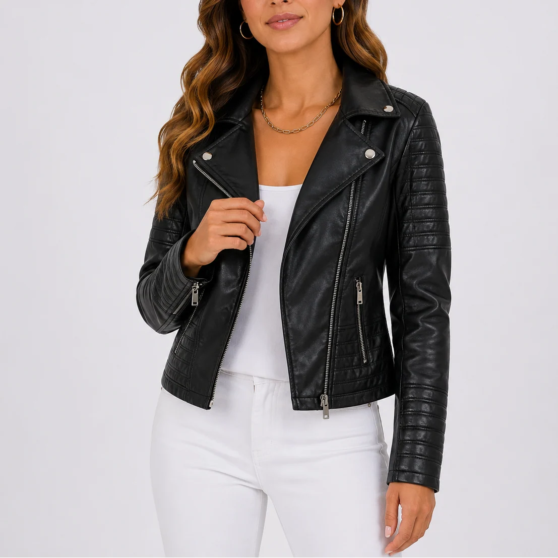 Women's biker jacket in black faux leather with asymmetric zip and quilted sleeves worn over white top