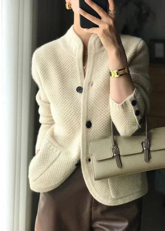 Close-up view of cream button-up cardigan showing textured knit construction and relaxed fit