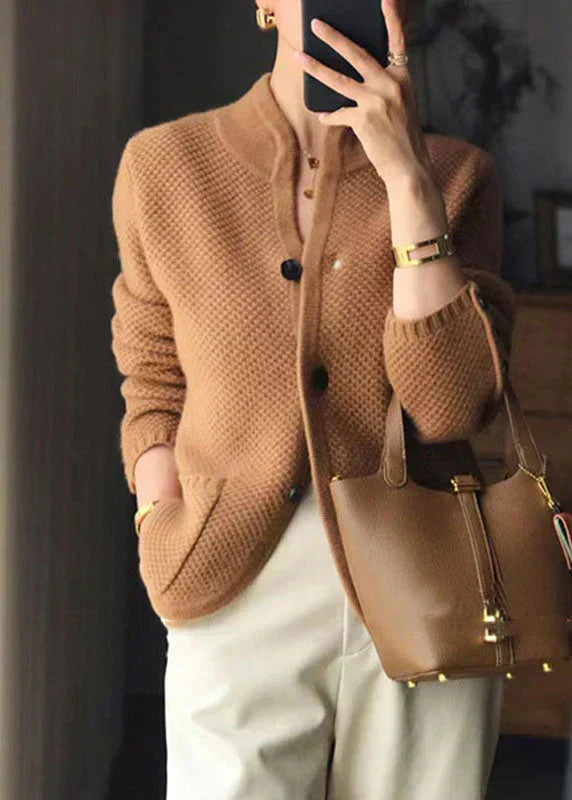 Detail shot of button-front closure and ribbed hem on cream textured knit cardigan