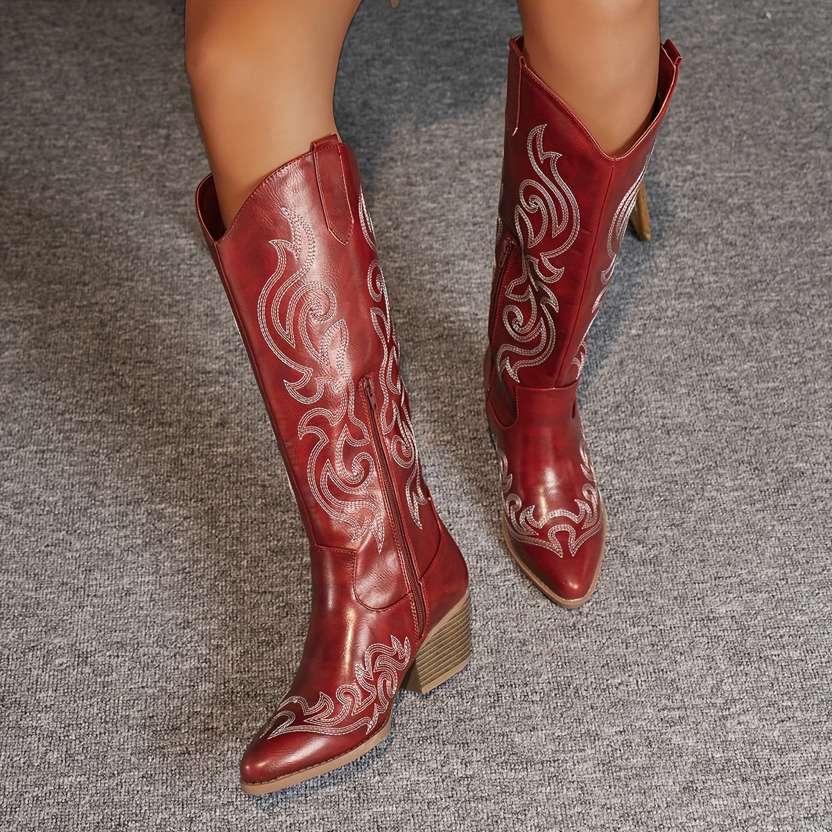 Women's embroidered cowboy boots in white displayed on rustic wooden surface with bohemian styling