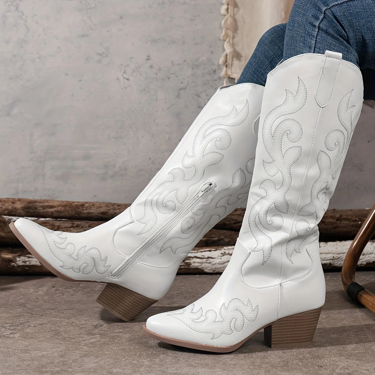 Close-up of pointed toe and embroidered shaft on women's western-inspired knee-high boots