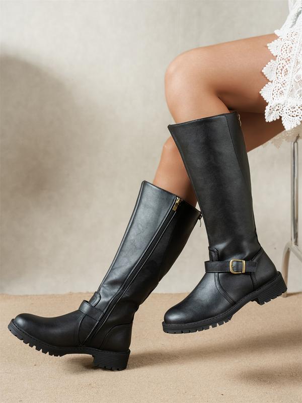 Side view of women's knee-high boots with side zip closure and ridged sole