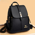 Men's leather backpack in black with structured silhouette, flap-over closure, and metal buckle detail on beige background