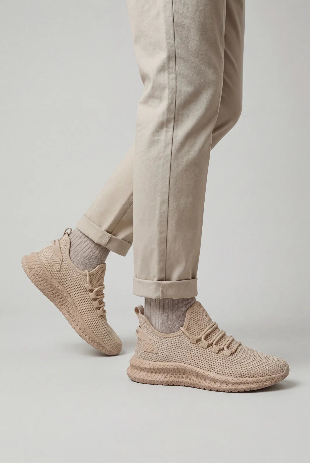 Front angled view of men's mesh trainers showing open-weave upper and pull tab detail