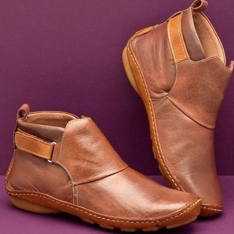 Side view of slip-on ankle boots showing tan pull tab and cushioned footbed construction