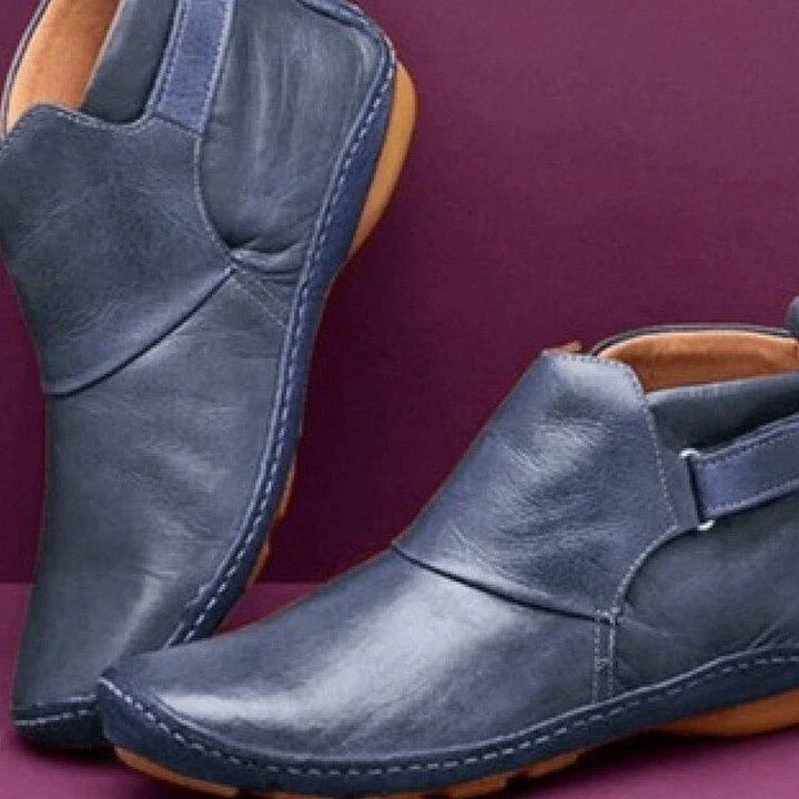 Close-up of women's flat ankle boots featuring round toe design and visible contrast stitching
