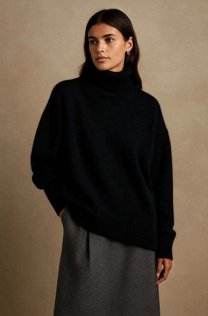 Woman wearing oversized black turtleneck jumper with relaxed fit and ribbed cuffs styled with grey skirt