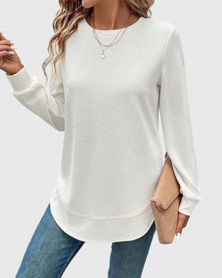 Side view of women's ribbed knit jumper with curved hem and relaxed fit through body