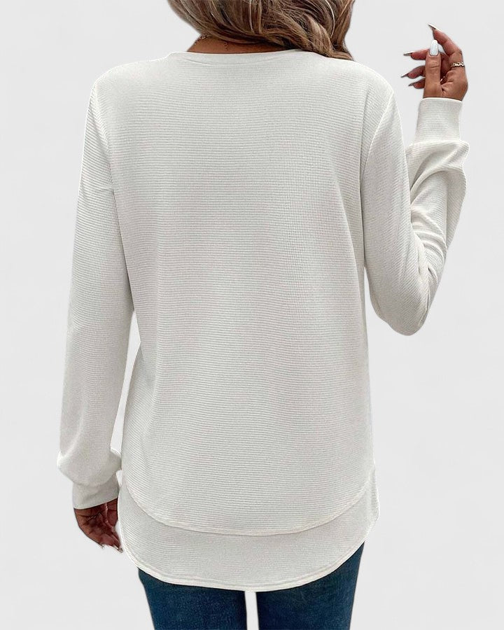 Women's ribbed knit jumper styled with jeans showing relaxed silhouette and long sleeve detail