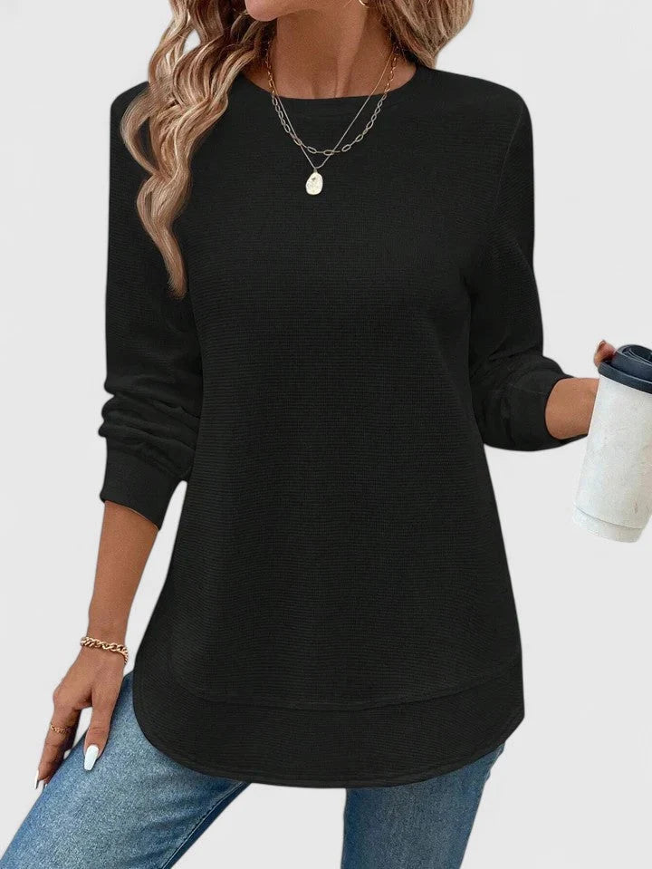 Women's ribbed knit jumper in teal blue worn casually with relaxed fit and curved hem