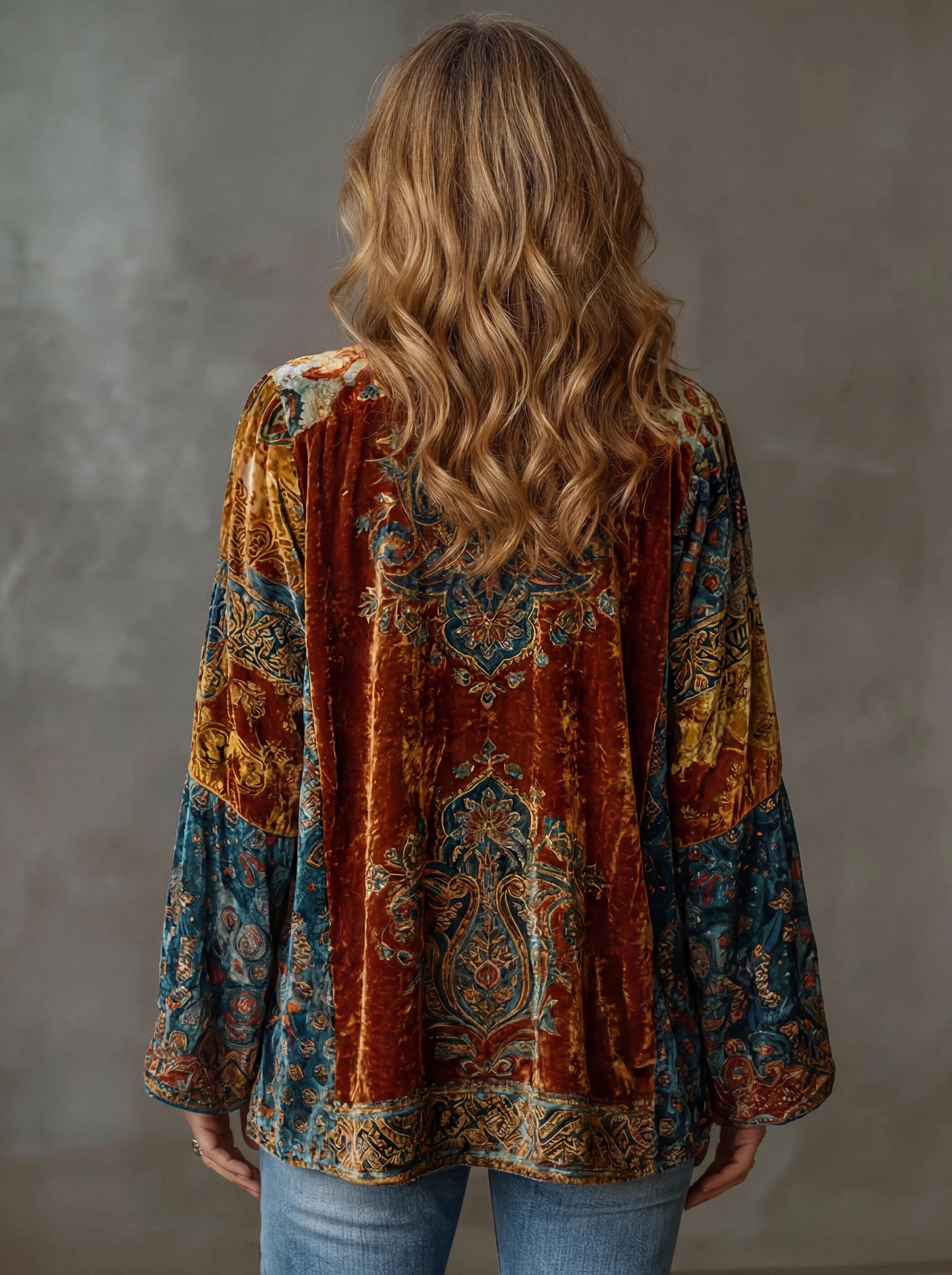 Side view showing the relaxed open-front silhouette and wide sleeves of the velvet bohemian cardigan draped elegantly