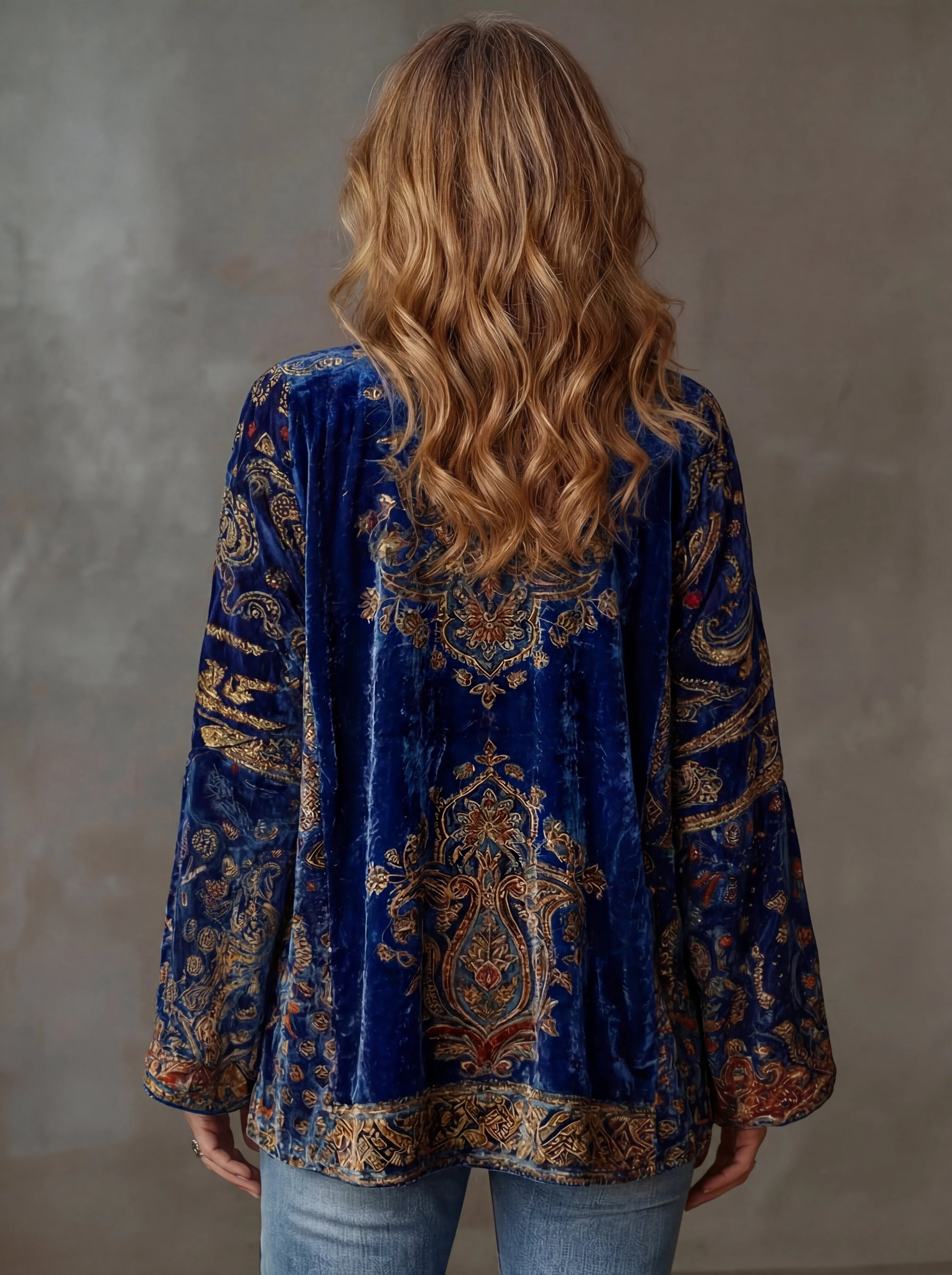 Woman styling the bohemian cardigan with jeans and layered necklaces for a casual yet artistic look