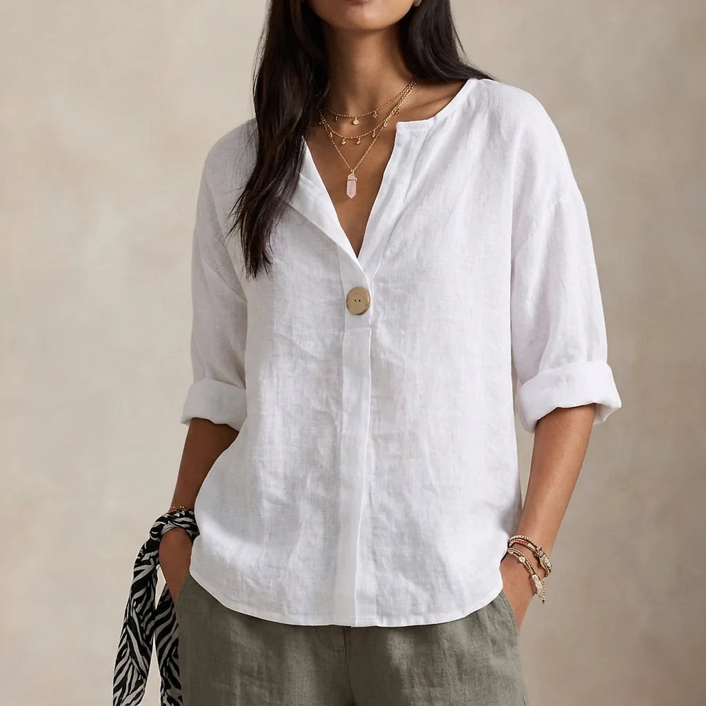 Close-up view of relaxed linen blouse showing V-neckline and single button closure detail