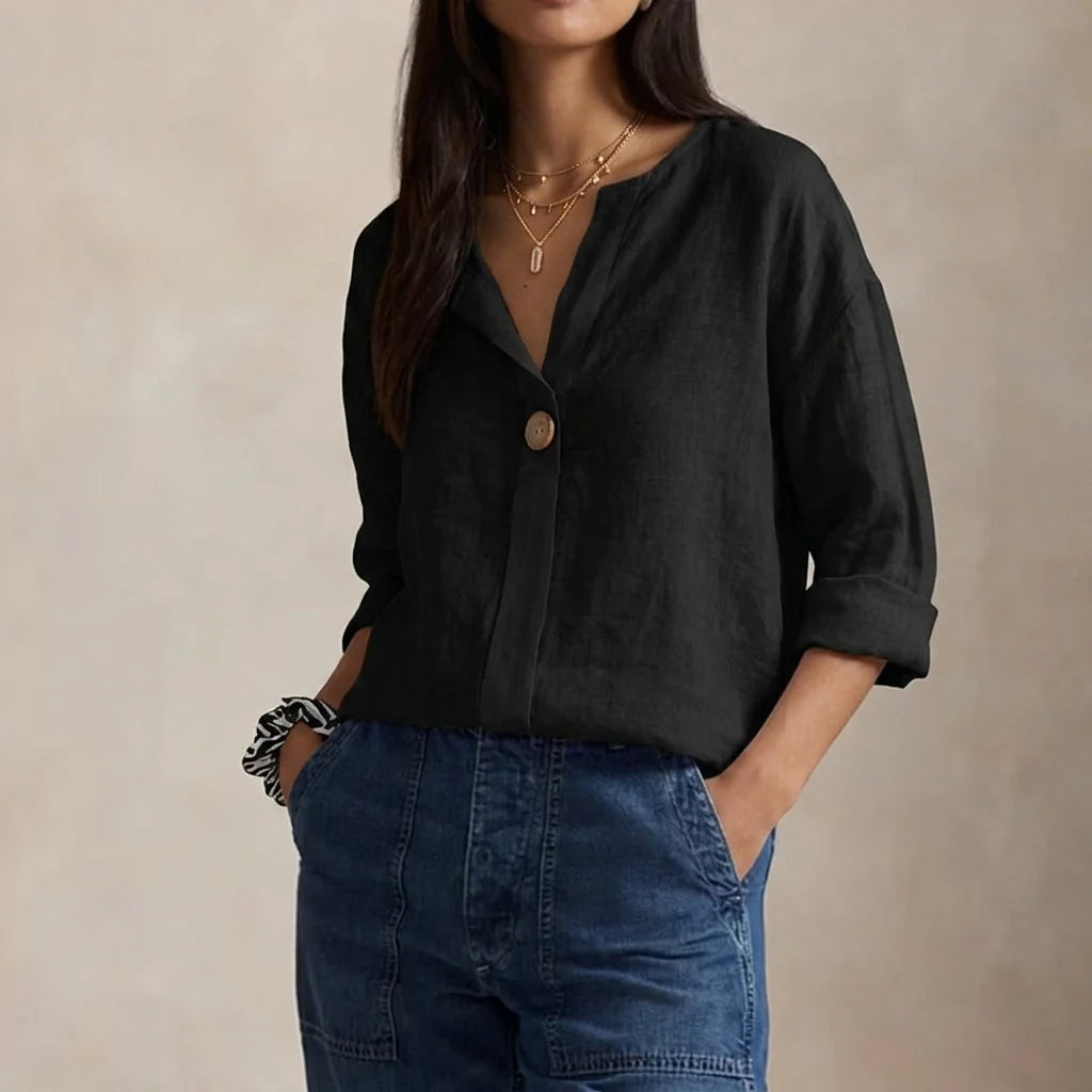 Side view of relaxed linen blouse featuring three-quarter sleeves and curved hem