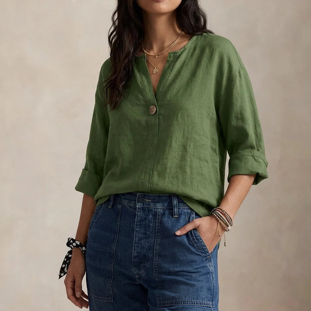 Detail shot of rolled three-quarter sleeves on relaxed linen blouse with soft drape