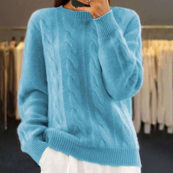 Women's cable knit jumper in cream showing relaxed fit and textured knit construction