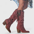 Rear view of knee-high boots with fringe trim and side zip closure