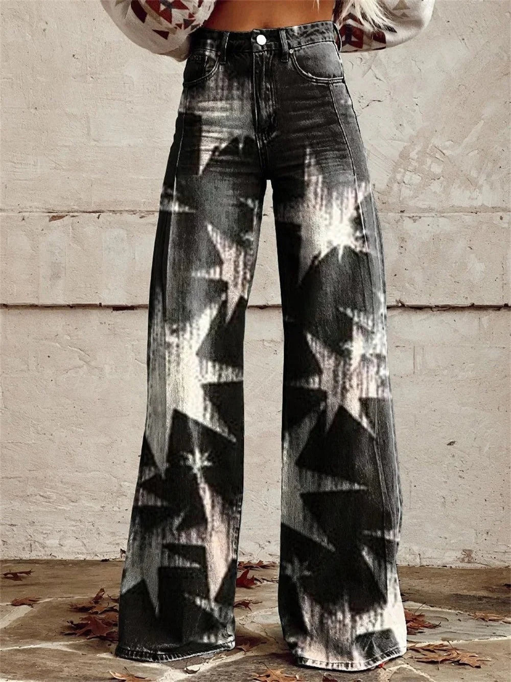 Close-up of relaxed wide leg trousers showing multicolour star print and high waist button closure