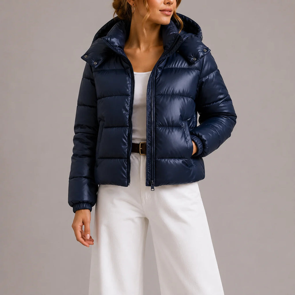 Side view of women's navy puffer jacket showing relaxed fit and glossy quilted shell
