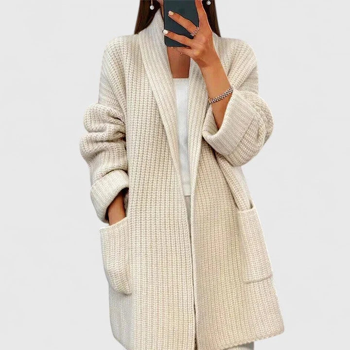 Close-up view of oversized knit cardigan showing relaxed fit and deep front pockets in neutral taupe