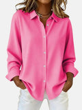 Women's oversized shirt in bright pink with classic collar and button-through front, styled with white trousers
