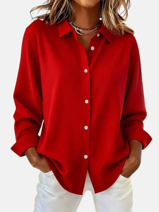 Side angle of women's oversized button-up shirt highlighting long sleeves with rollable cuffs and flowing drape