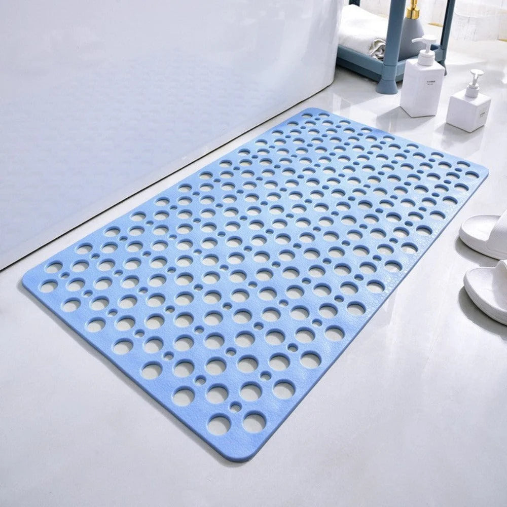 Non-slip shower mat in light blue with perforated drainage holes on bathroom floor