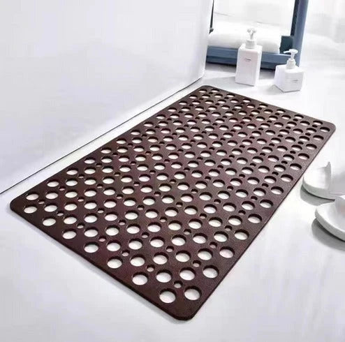 Non-slip mat with drainage holes and suction grip for wet floor use