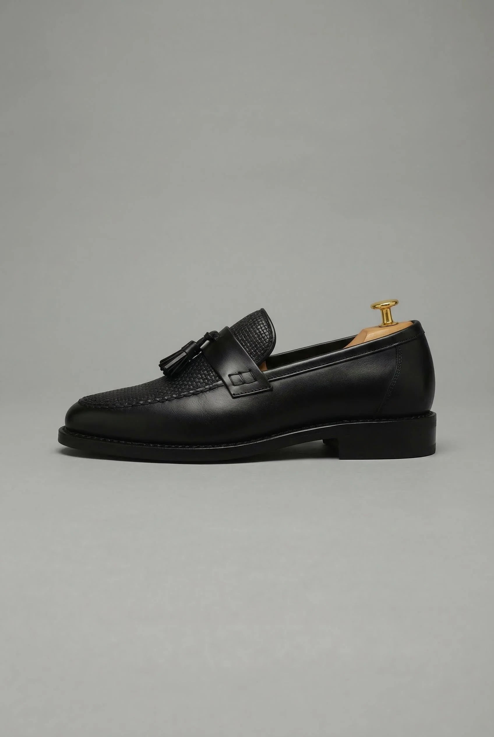 Side profile of men's tassel loafers displaying classic silhouette and tassel accent detail