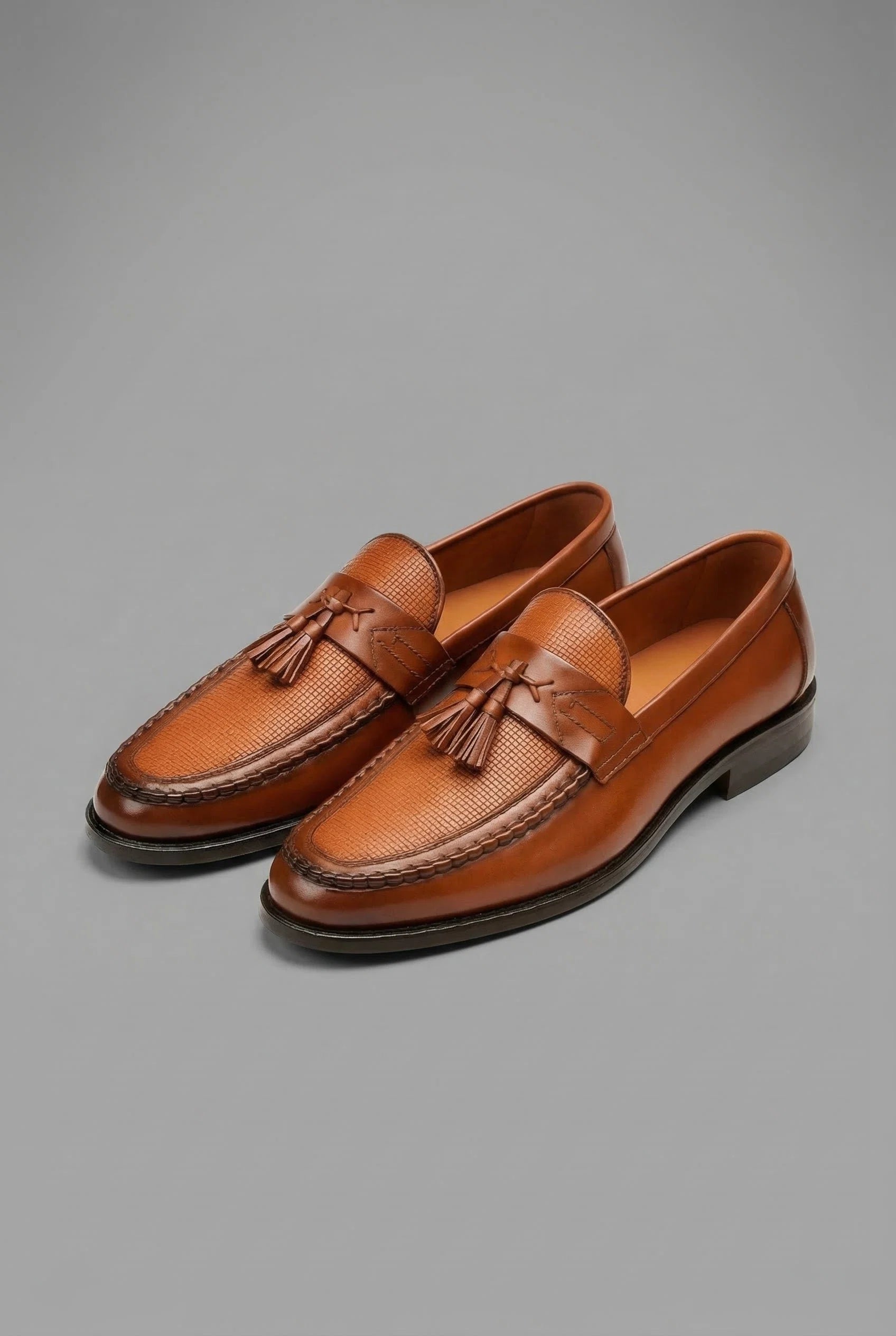 Detail shot of tassel accent and woven texture on men's formal loafers