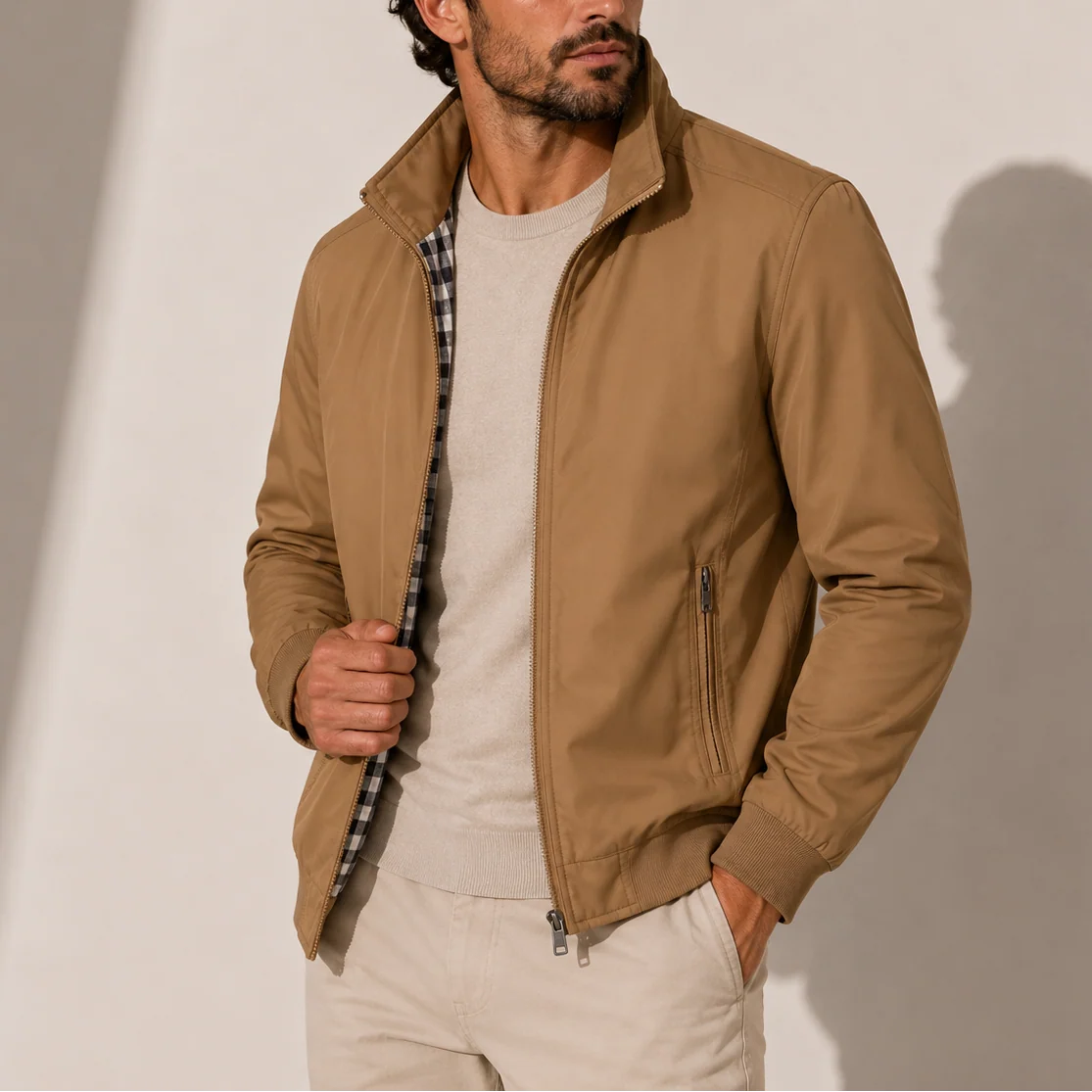 Close-up of men's bomber jacket showing stand collar, zip detail and checked inner lining