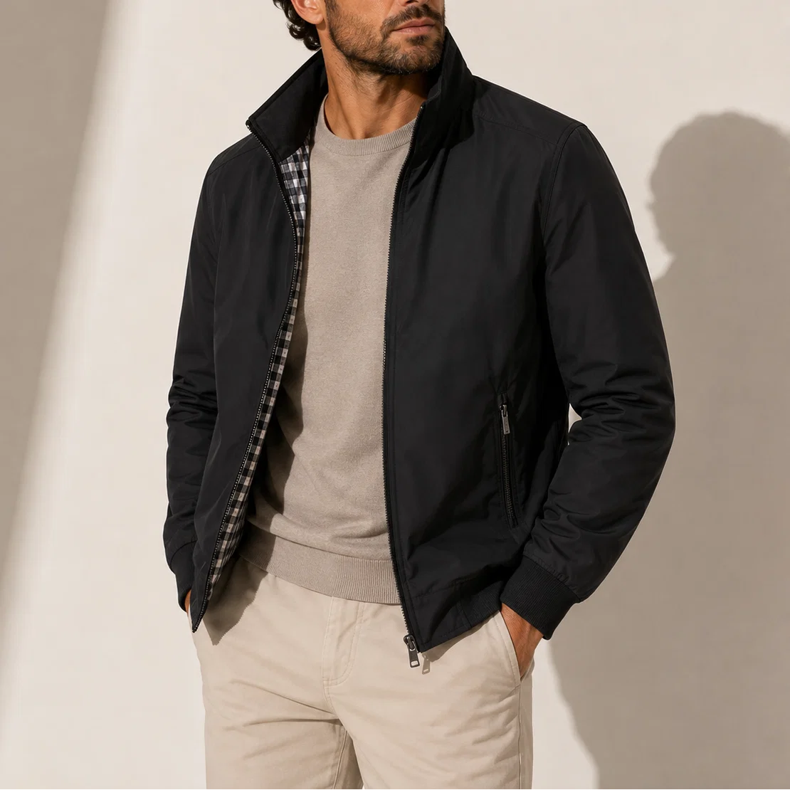 Men's bomber jacket styled with beige chinos and polo shirt for smart-casual look