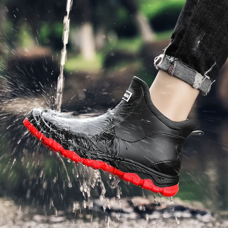 Pair of men's Chelsea boots displayed on natural stone background