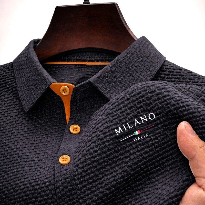Detail shot of contrast button placket on men's textured polo shirt with embroidered branding on chest
