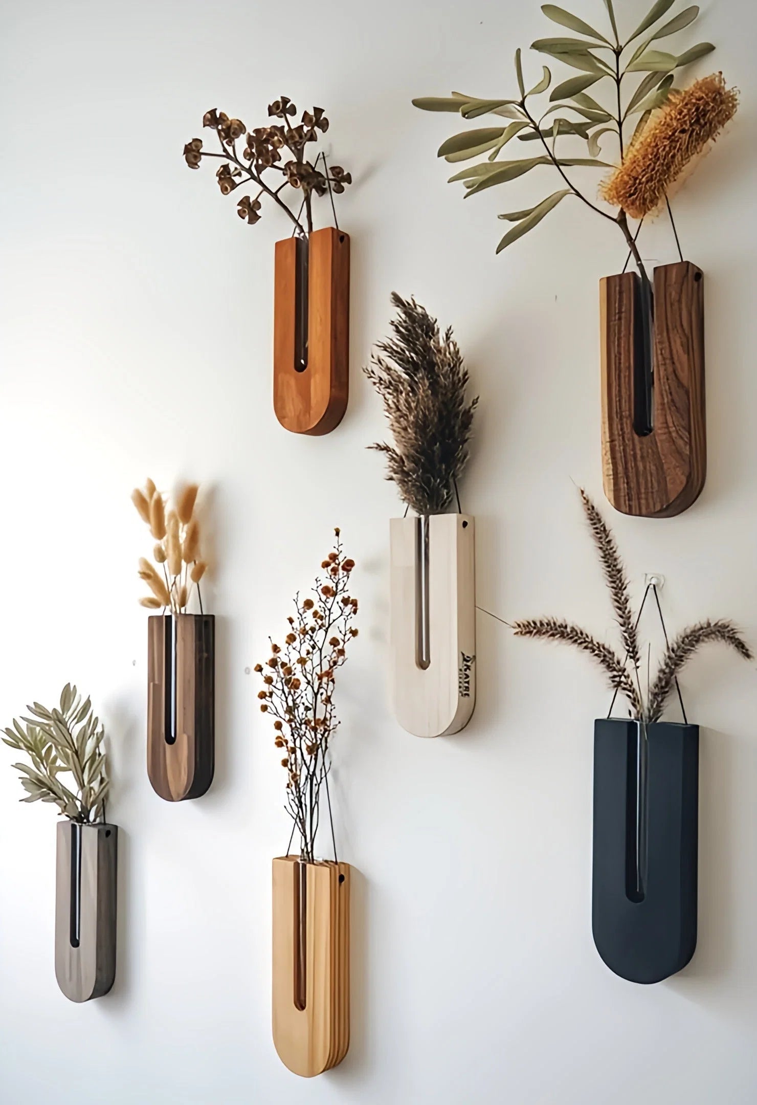 Wooden wall planter set featuring seven U-shaped holders in natural wood tones displaying dried botanicals on white wall