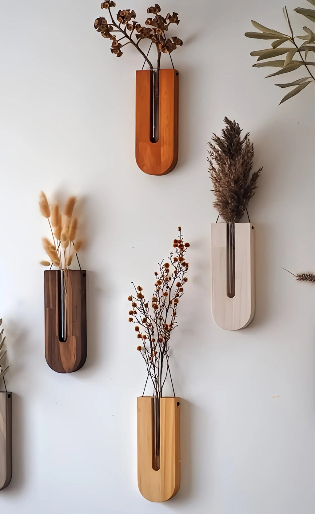 Vertical arrangement of wall-mounted wooden planters holding pampas grass and dried flowers in mixed wood tones