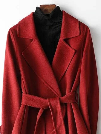 Close-up of burgundy belted wrap coat showing structured fabric and A-line silhouette