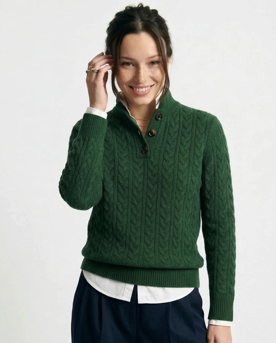 Close-up of cable-knit texture and button detail on olive cashmere cardigan