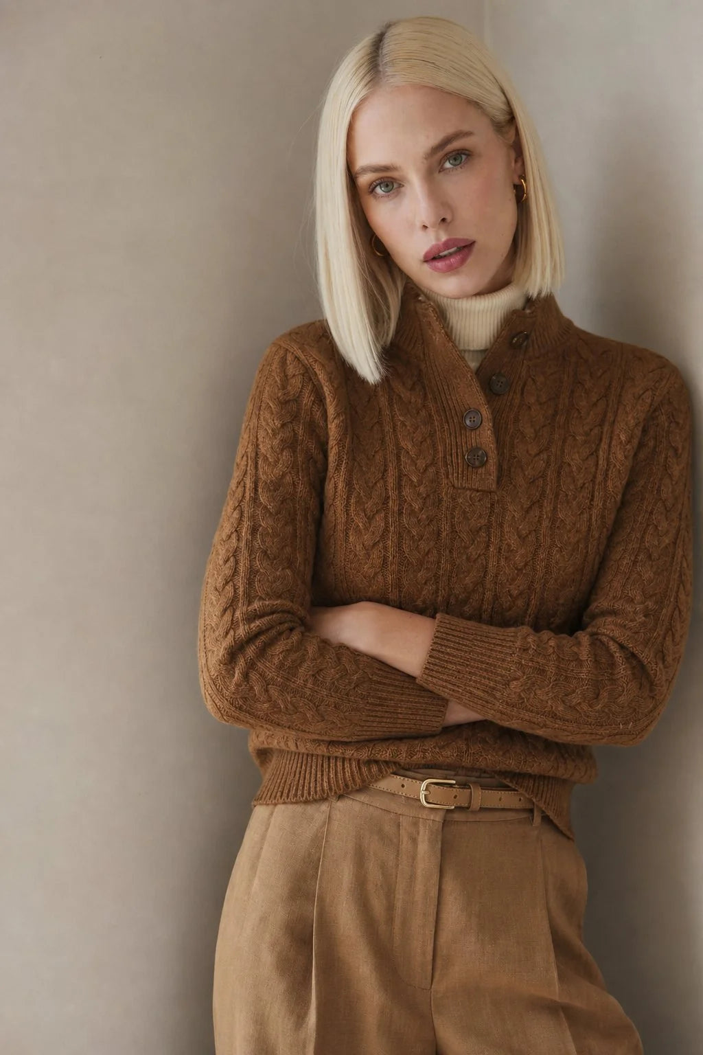 Close-up view of cable-knit pattern and button detail on women's cashmere cardigan with stand collar