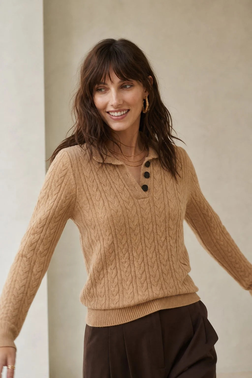 Detail shot of stand collar and button closure on cable-knit cashmere cardigan