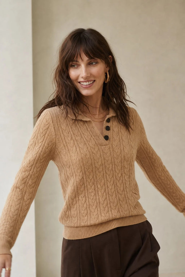 Detail shot of stand collar and button closure on cable-knit cashmere cardigan