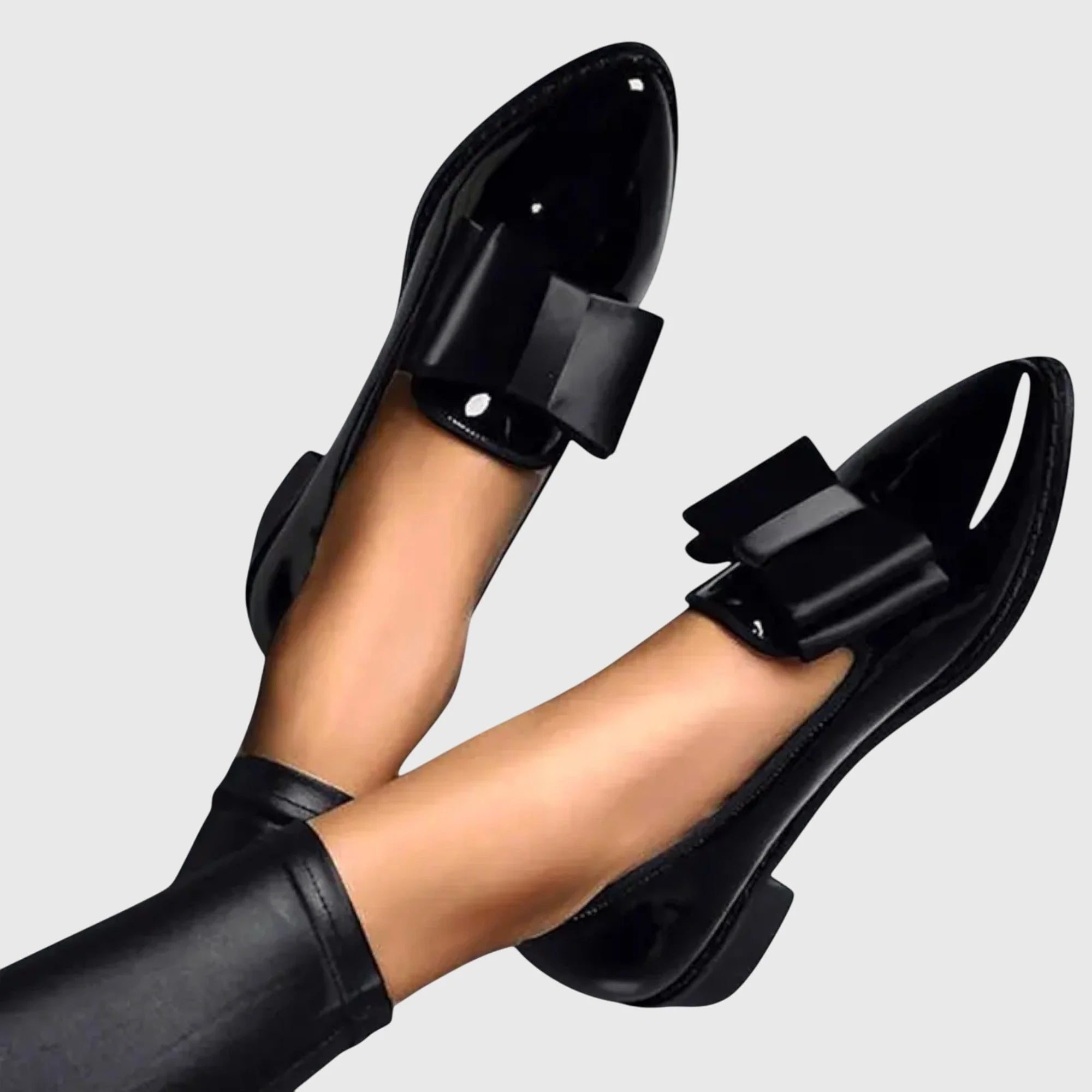 Side view of women's glossy patent loafers showing pointed toe silhouette and flat heel construction