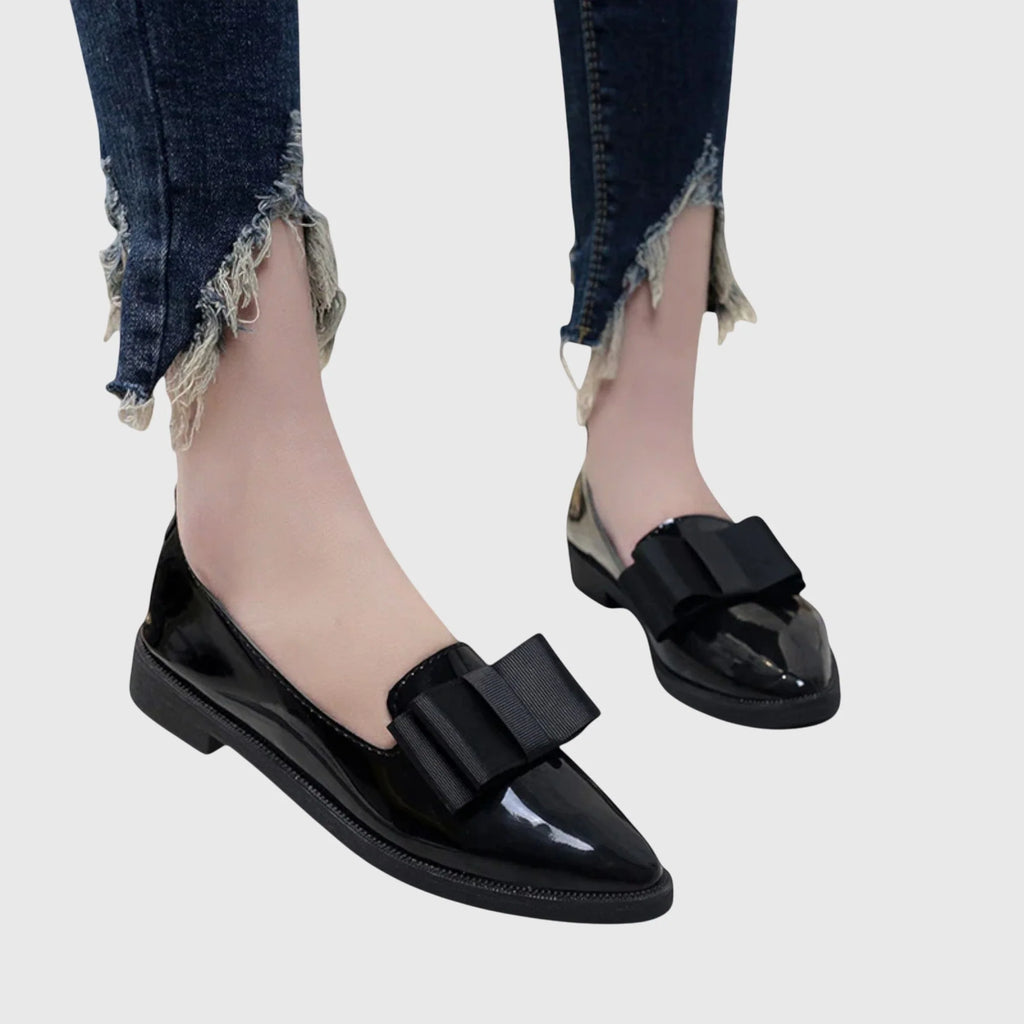 Close-up of bow detail on women's patent loafers with structured vamp and smooth finish